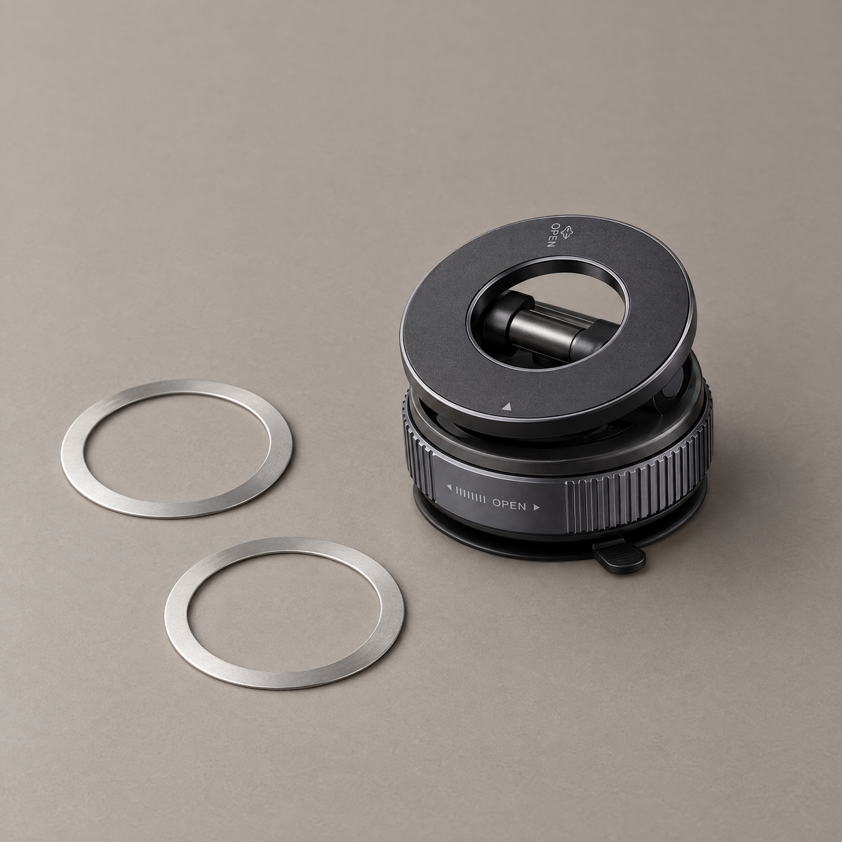 Folded graphite phone holder beside two metal attachment rings